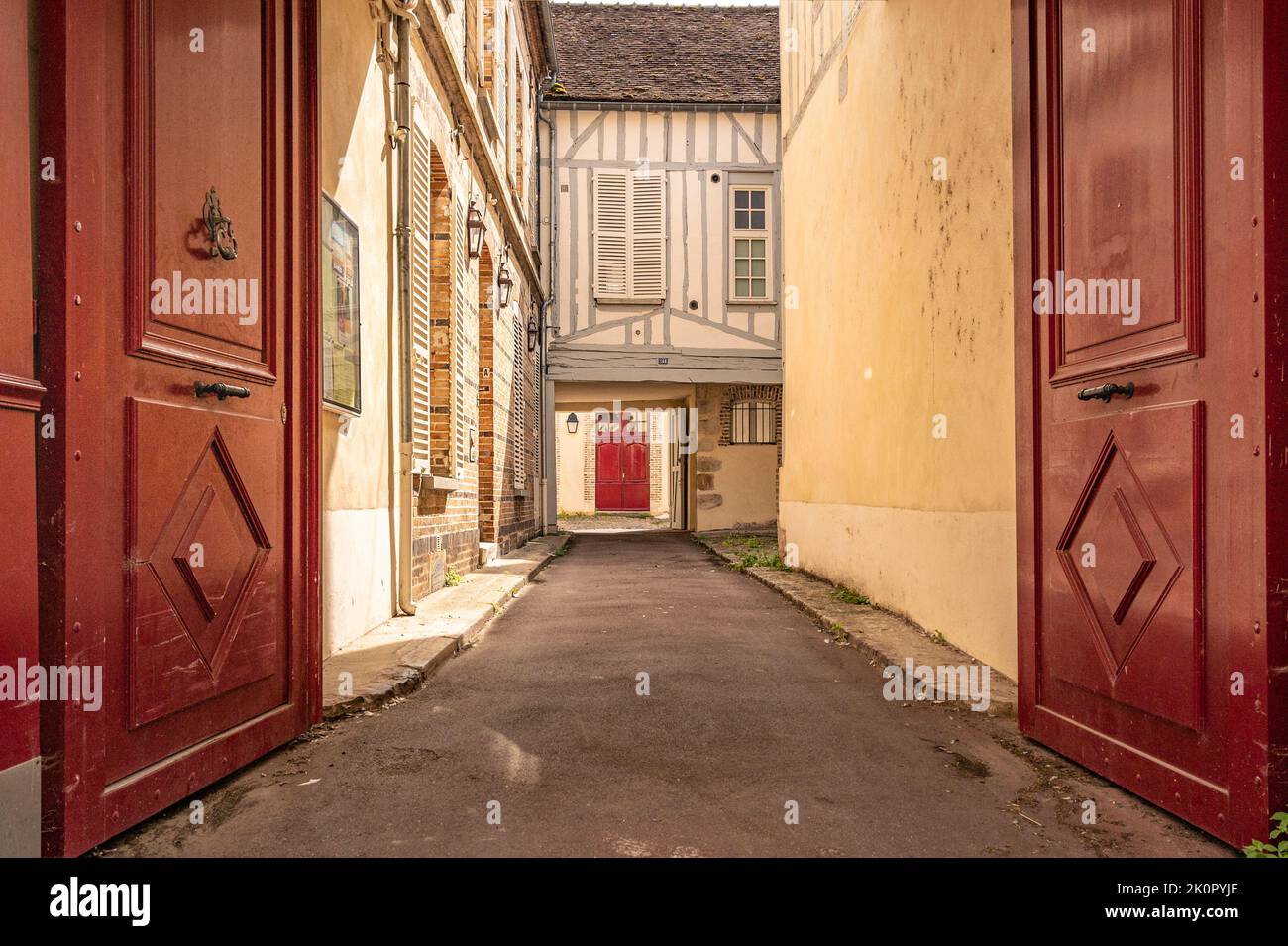 Behind high wooden gates, interior courtyards are typical of traditonal town houses at Sens, Burgundy, France Stock Photo