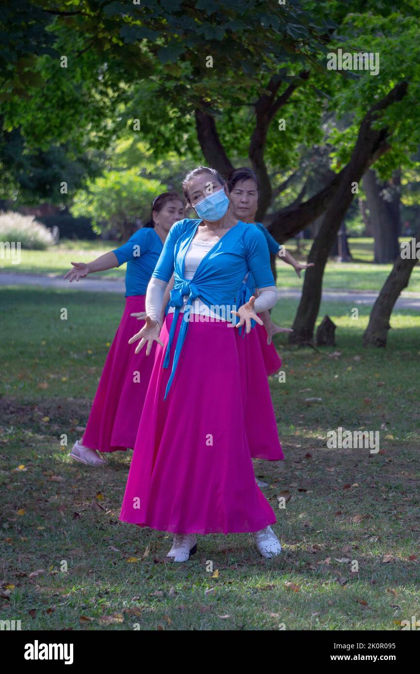 3 women including heir teacher at a daily dance exercise class in a park in Flushing, Queens, New York City perpetuating a Chinese tradition Stock Photo