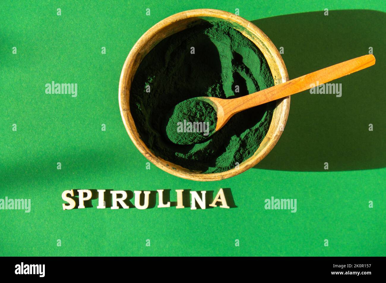 Bluegreen algae spirulina powder in bamboo eco bowl with text