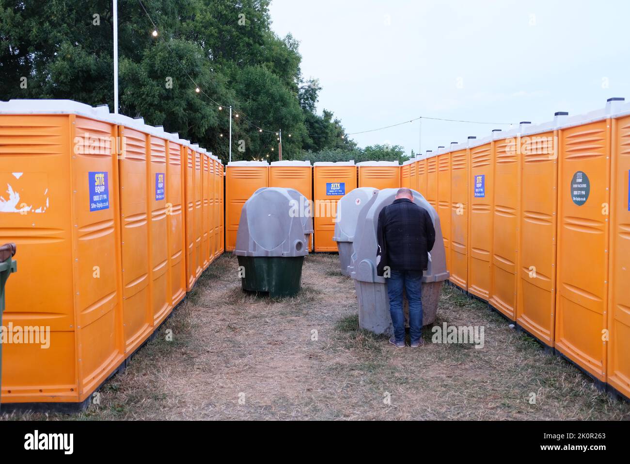 A man at the urinals at End of The Road festival. Stock Photo
