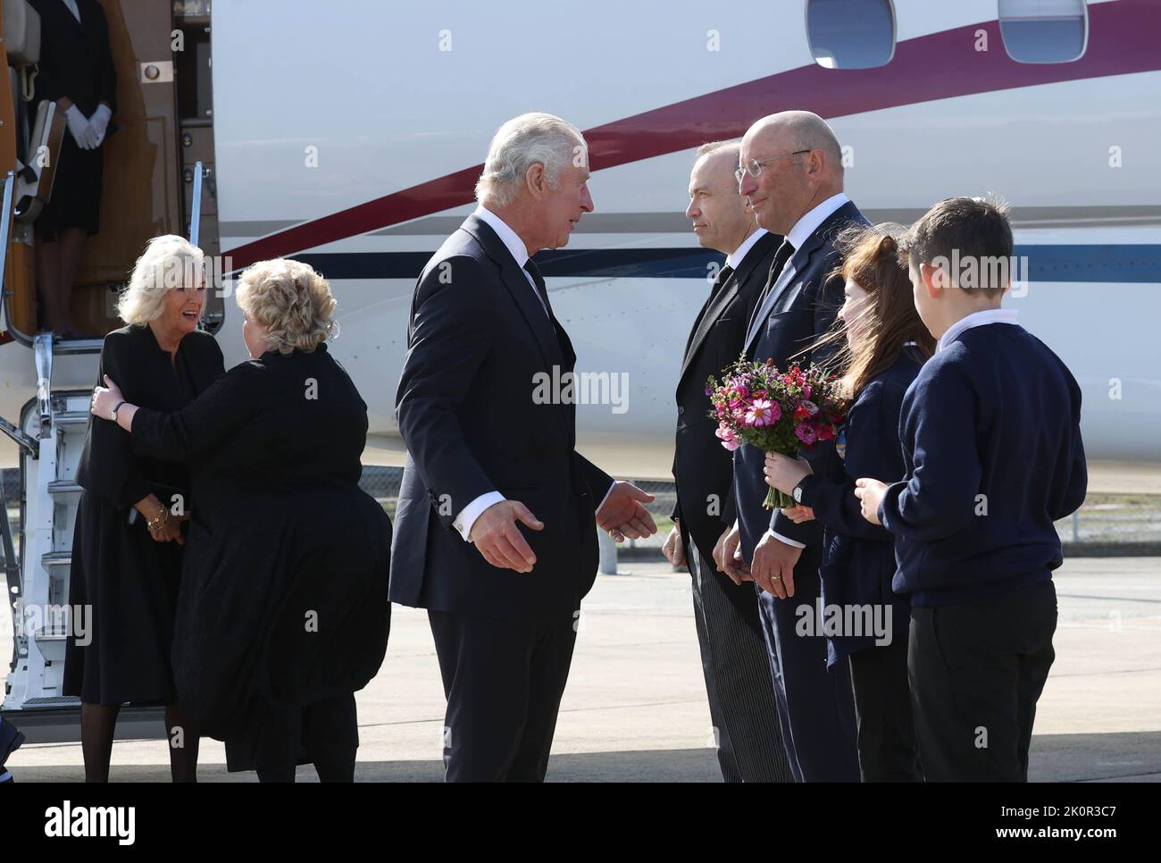 The Queen Consort (left) is greeted by Lord Lieutenant of Belfast