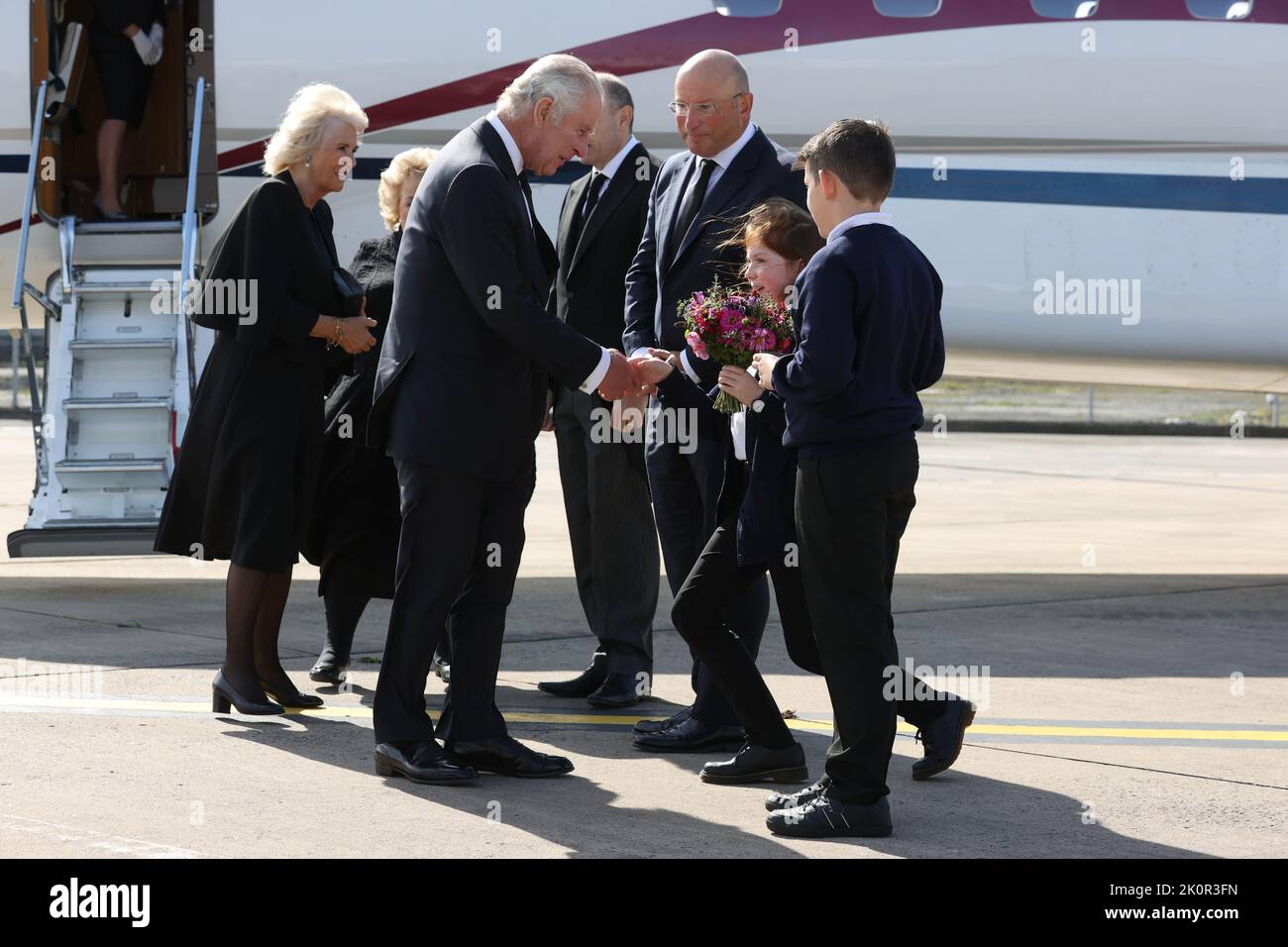 The Queen Consort (left) is greeted by Lord Lieutenant of Belfast