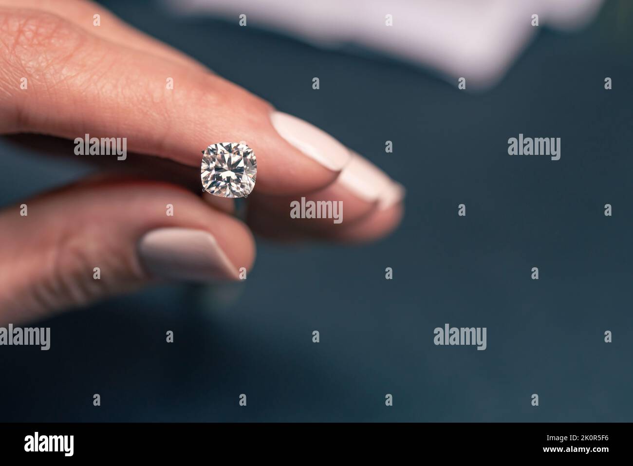 Woman Holding a Diamond With Tweezers Stock Photo