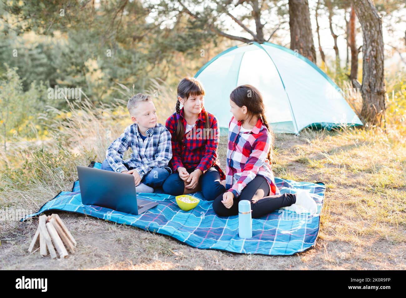 Sisters spending time in a tent on camping. Children using tablet playing games  online during summer vacation - a Royalty Free Stock Photo from Photocase