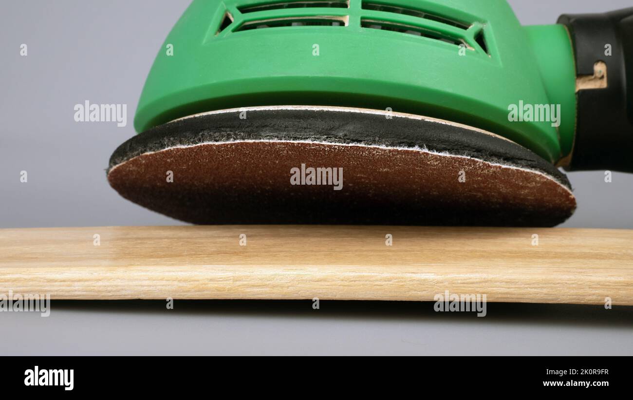 grinding and polish wooden board surface with grind sandpaper machine close up. Stock Photo