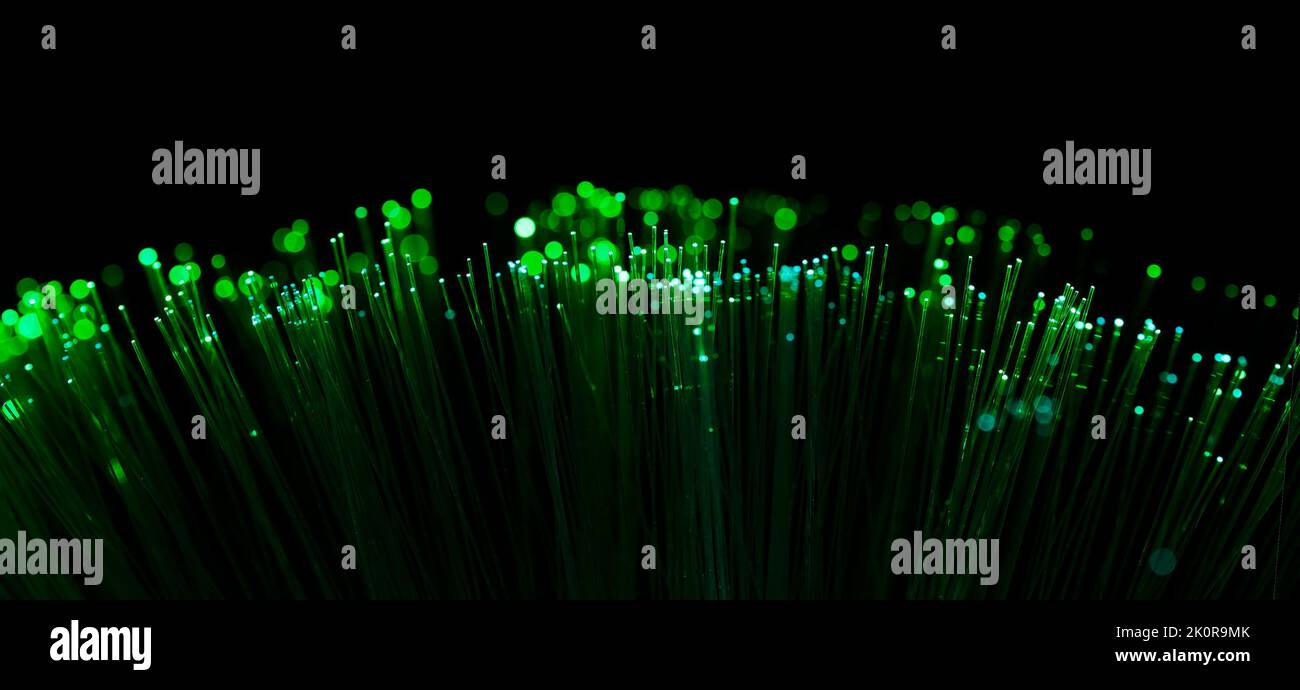 Fiber optic filaments glowing green. Wide format with black background Stock Photo