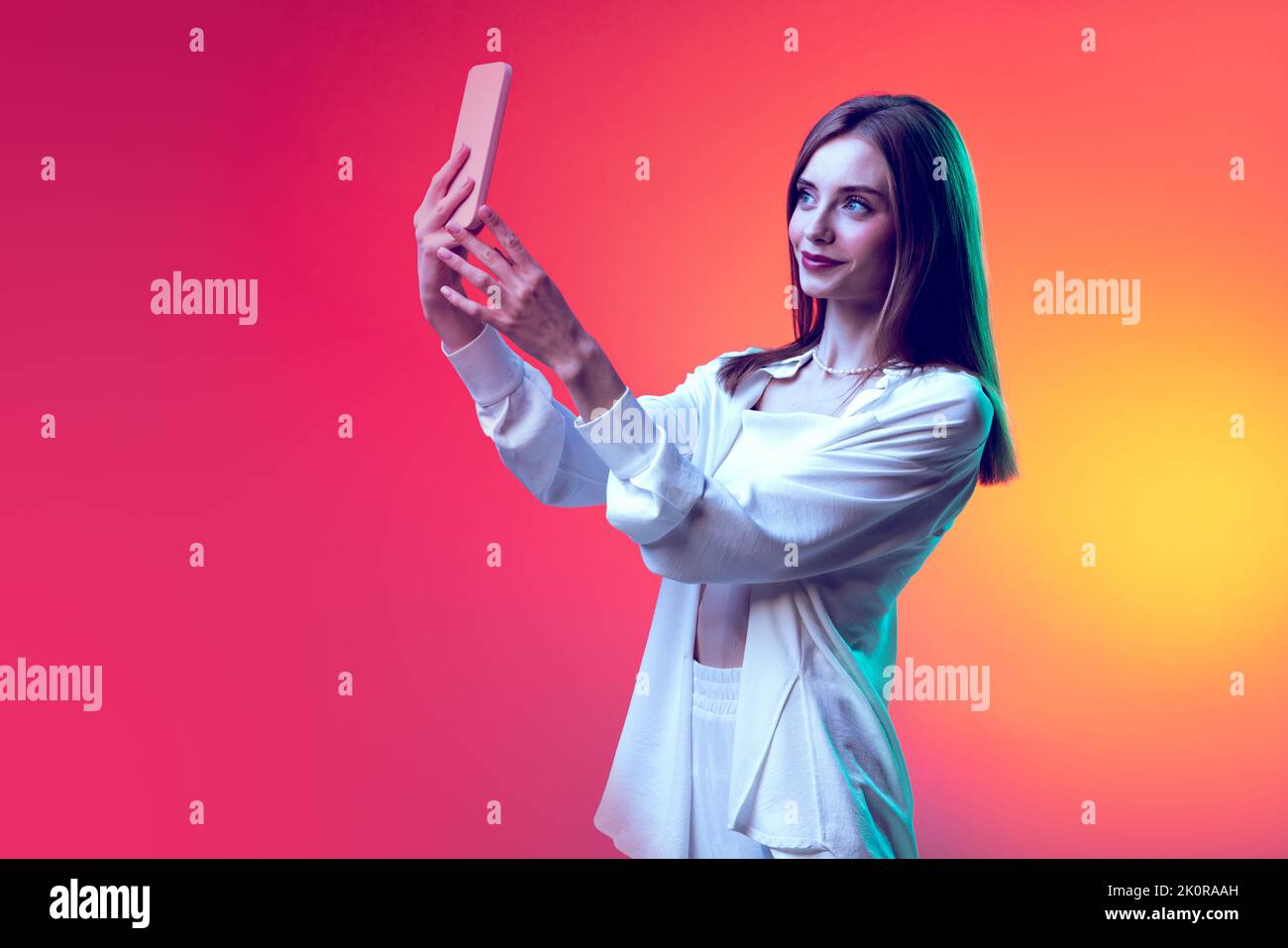 Portrait of young beautiful woman posing, taking selfie with phone ...
