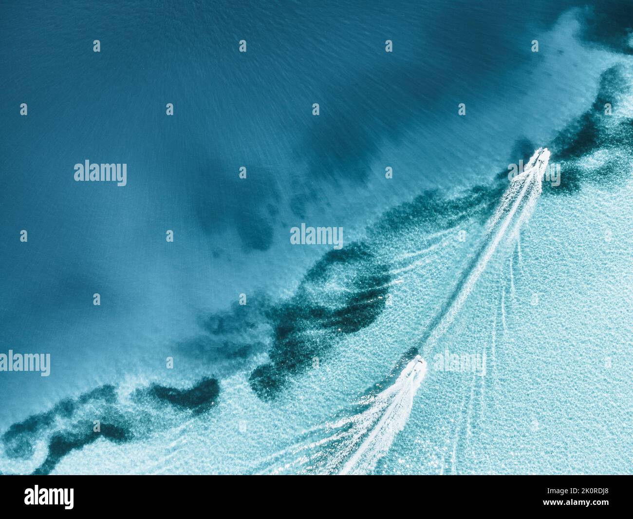 An aerial top shot of a boat leaving trail on clear seawater Stock ...
