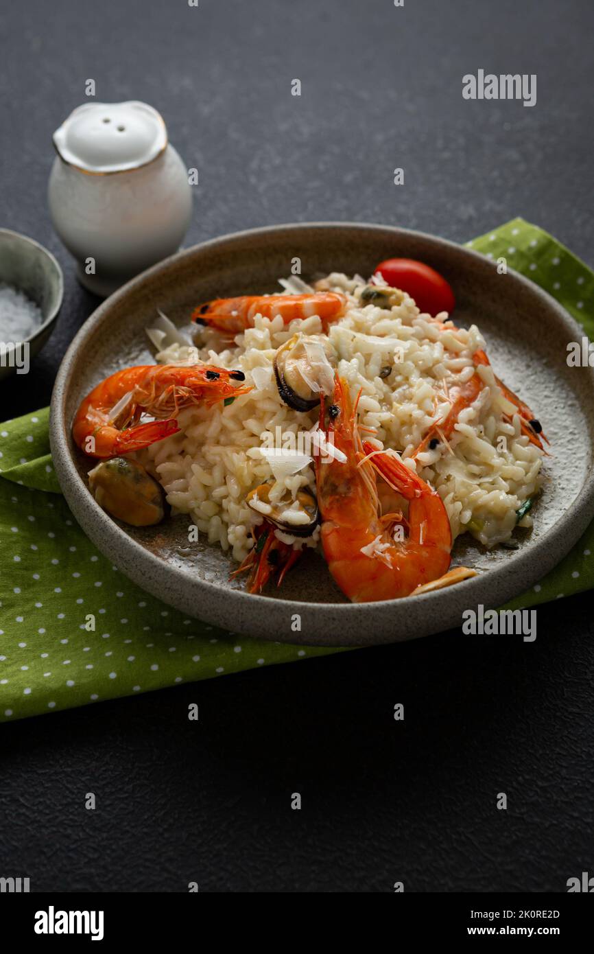Close up of Risotto with mussels and shrimps cheese in bowl italian food on black surface Stock Photo