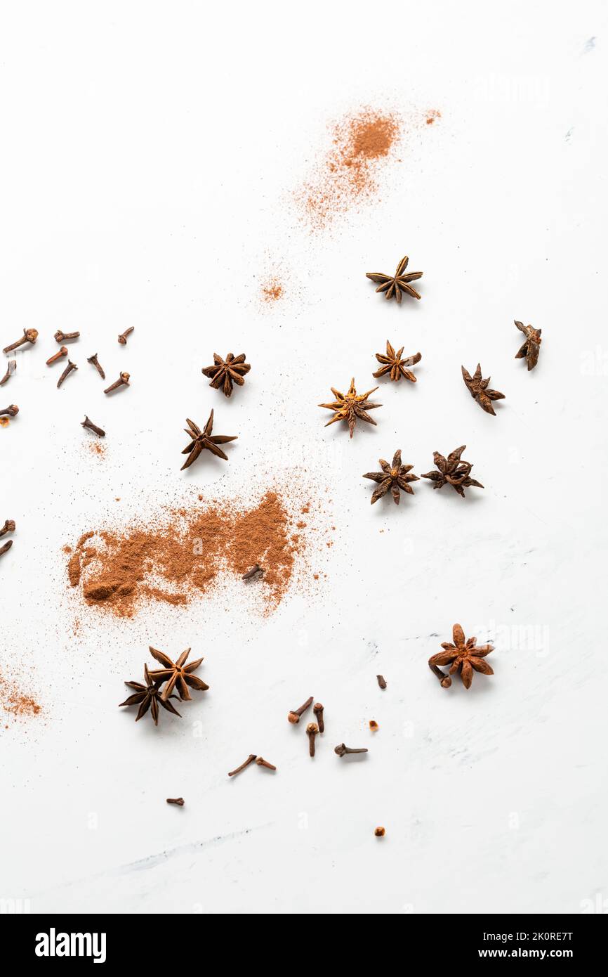 Cinnamon powder and anise star spice background on light surface Stock Photo