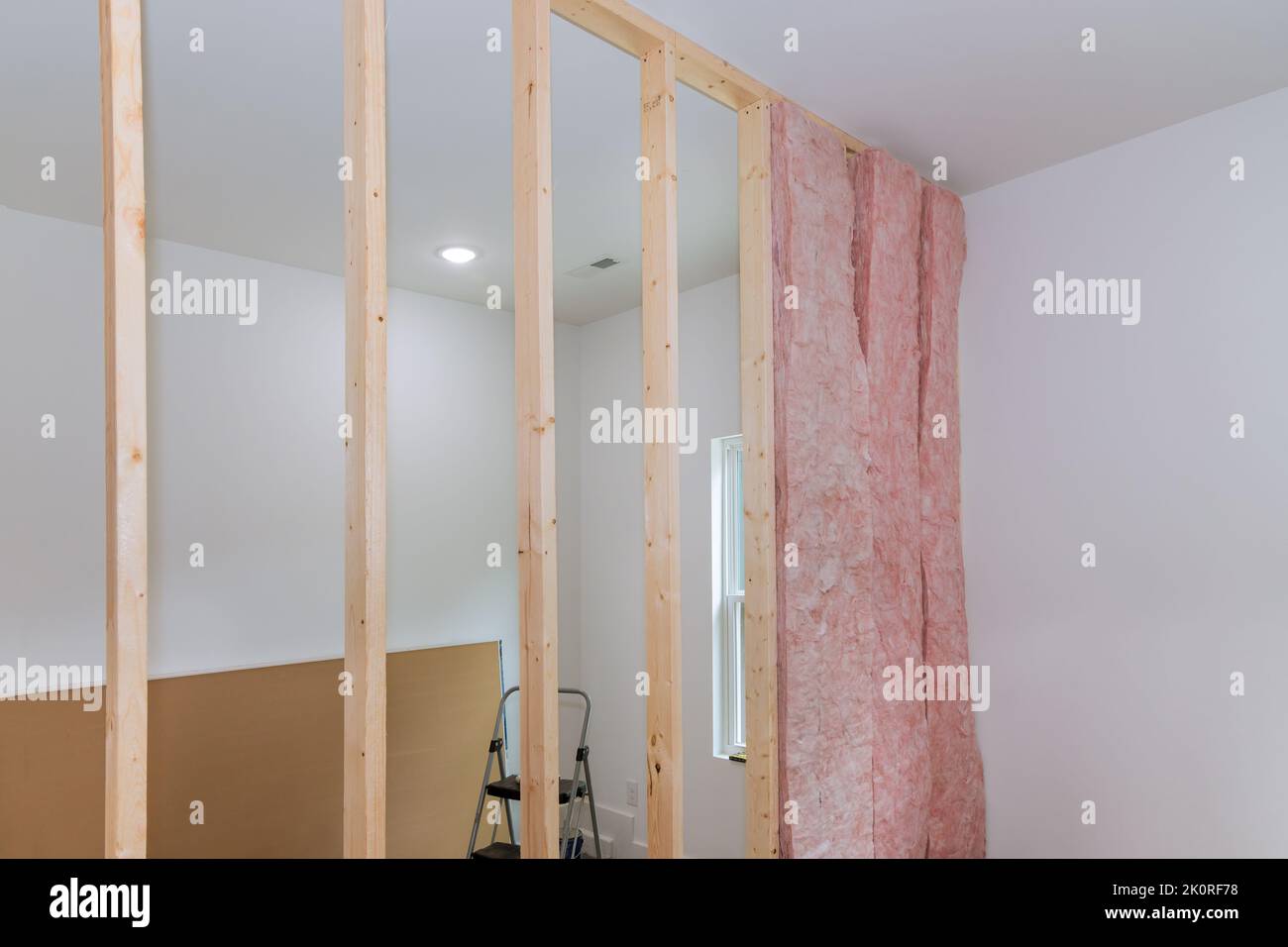 Installing interior thermal and sound insulation rockwool mineral fiber glass wool among beams framing for wall Stock Photo