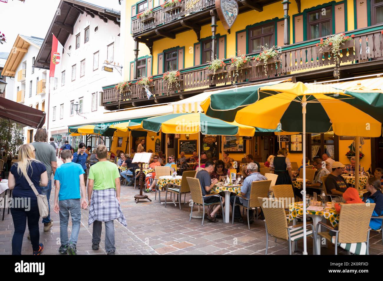 Inner city of Zell am See, Austria, with strolling tourists and a restaurant terrace Stock Photo