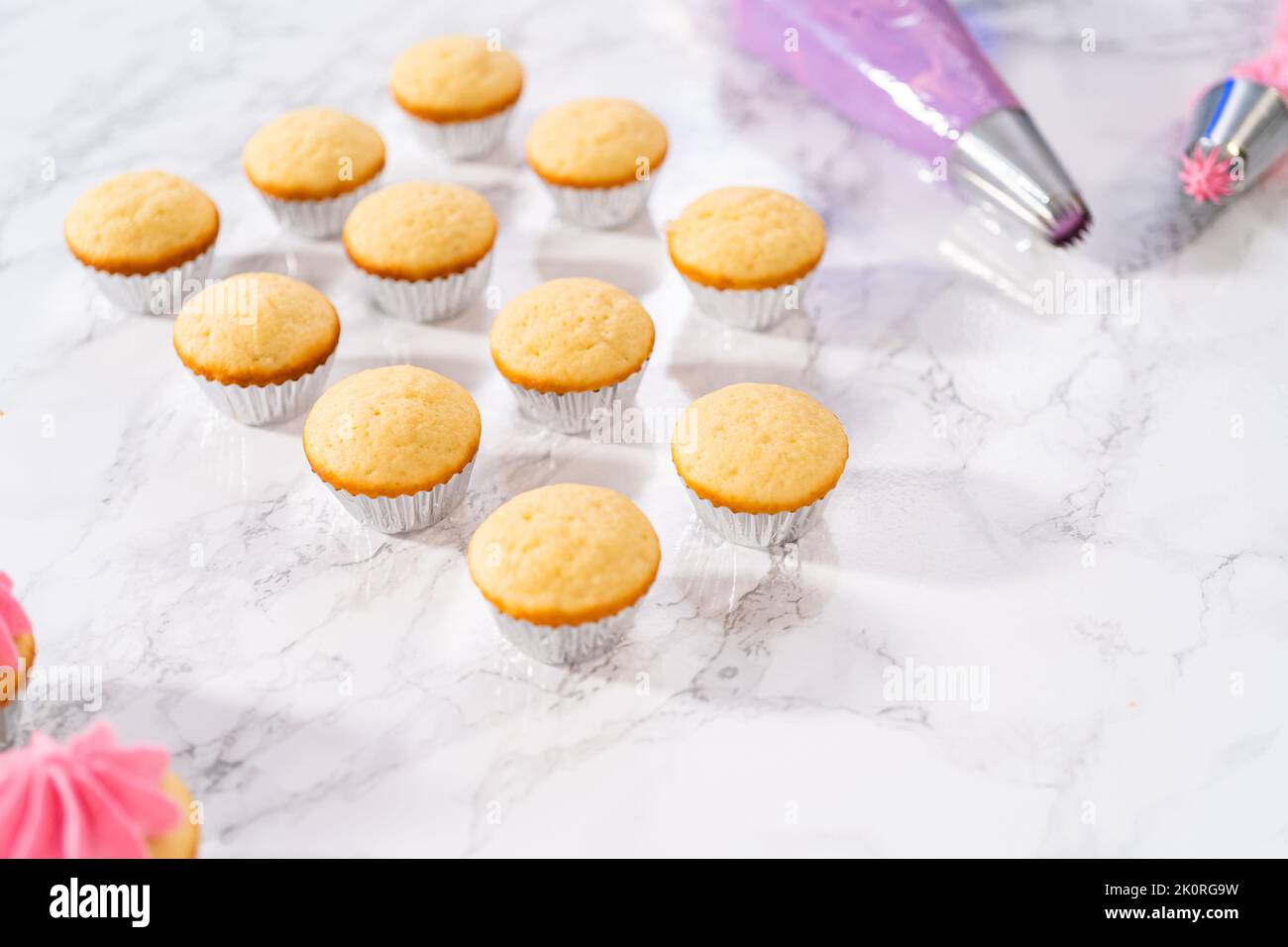 Mini Vanilla Cupcakes with Pink Buttercream Frosting Stock Photo - Alamy