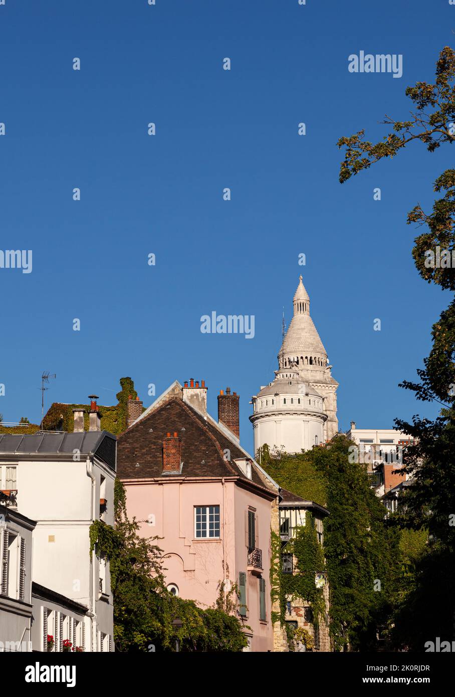 View of the Montmartre quarter with the Pink House restaurant called La Maison Rose and the Basilica of Sacred Heart in french language the Sacre Cœur Stock Photo