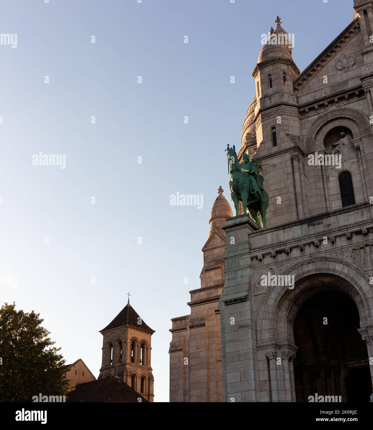 Sacre Coeur basilica, 'Basilica of the Sacred Heart of Jesus' with the Jeanne d'Arc statue in front of the main entrance. Paris, Montmartre, France. Stock Photo