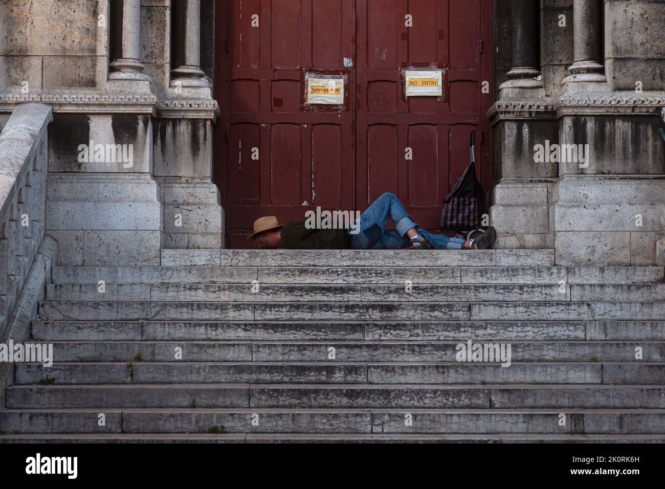Man laying on the steps of the Sacred heart Basilica in Paris, France Stock Photo