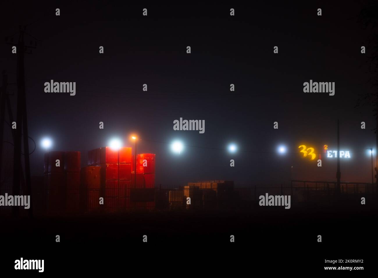 landscape foggy night deserted road with lanterns. Stock Photo