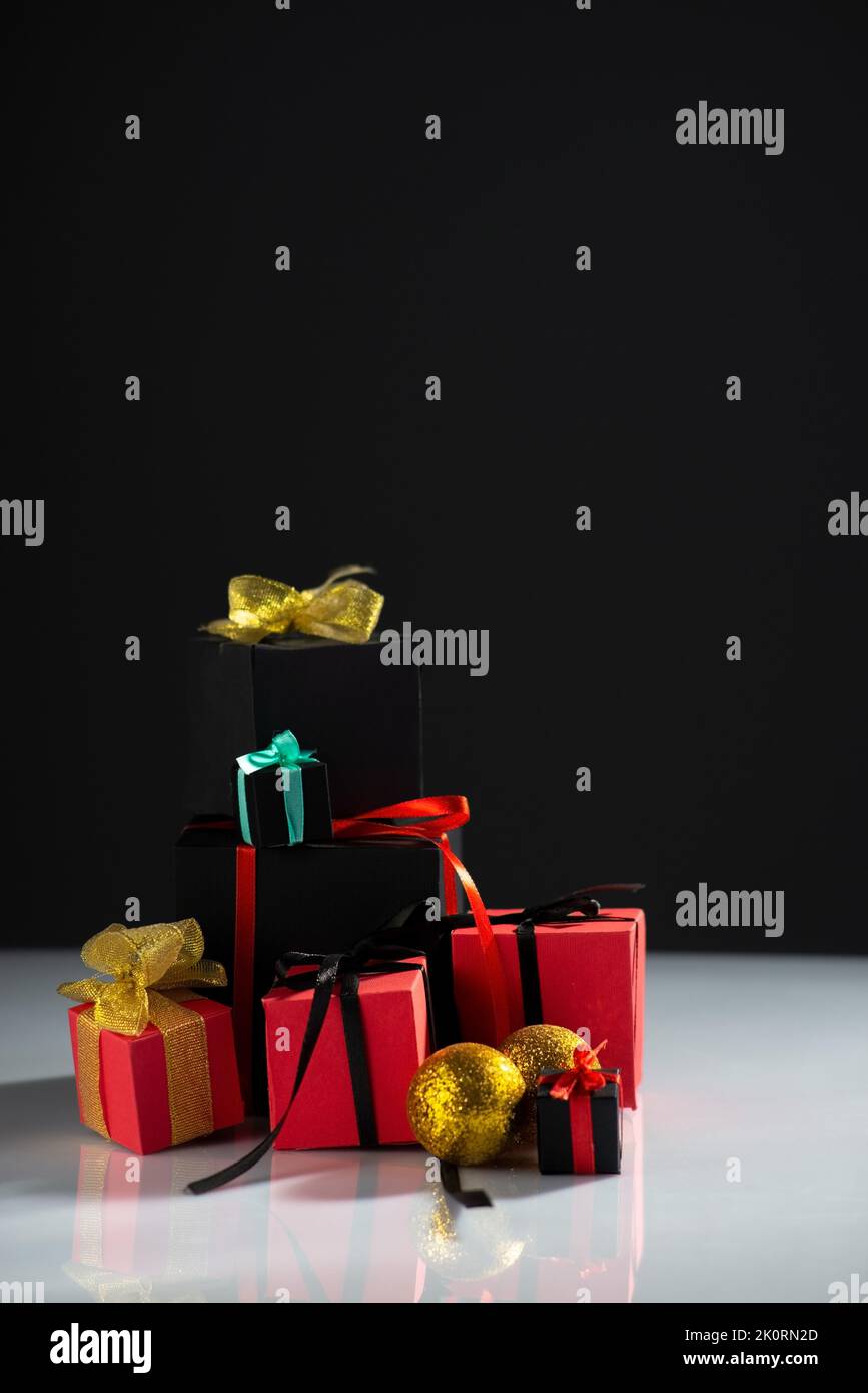 New Year's red-black gifts on a white table and a black background. Stock Photo