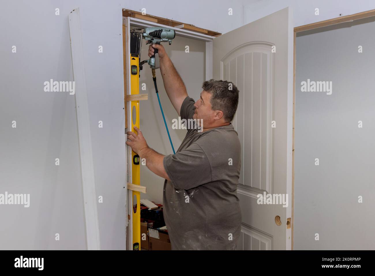 The interior doors are being installed in a new house by a trim worker Stock Photo
