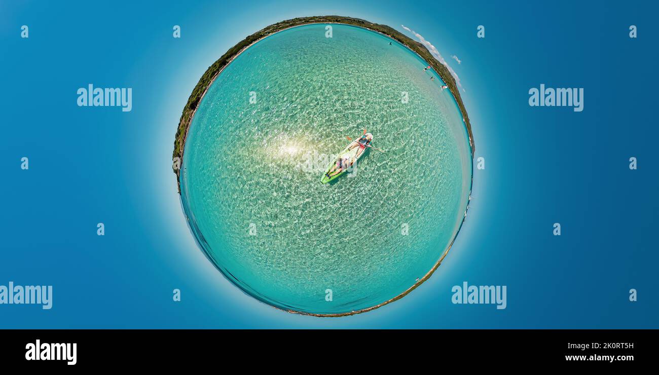 People kayaking in Mediterranean by Piana island and Petit Sperone beach Concept of environment. Tiny planet 360 view of kayak from Piantarella beach Stock Photo