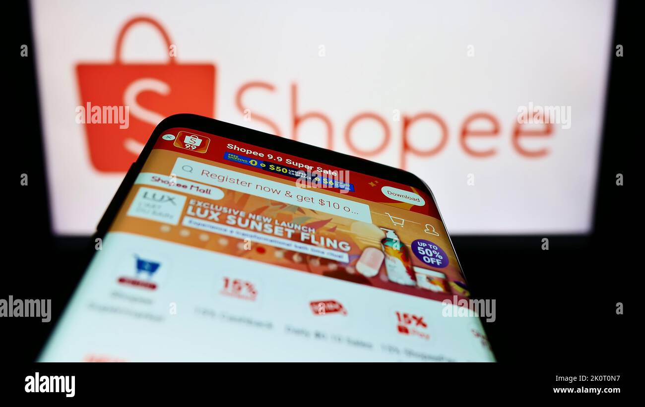 Shopee is e-commerce technology company. Smartphone with Shopee logo on the  screen, shopping cart and parcels Stock Photo - Alamy