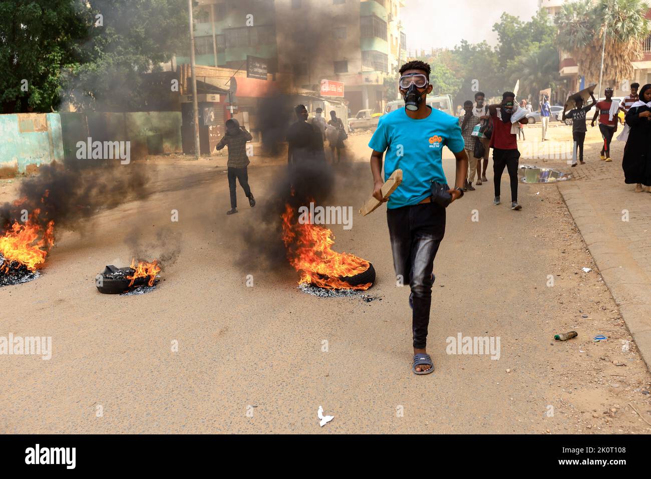 Protesters march past burning tires during a rally against the military rule following the last coup, in Khartoum, Sudan September 13, 2022. REUTERS/Mohamed Nureldin Abdallah Stock Photo
