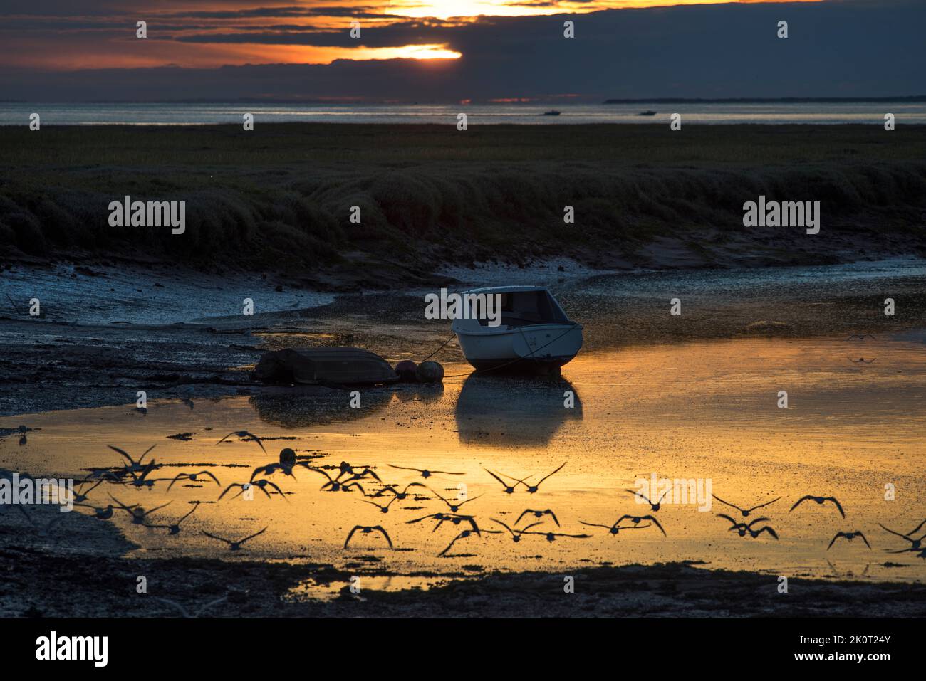 Fishing boat at low tide with beautiful  sunset Stock Photo