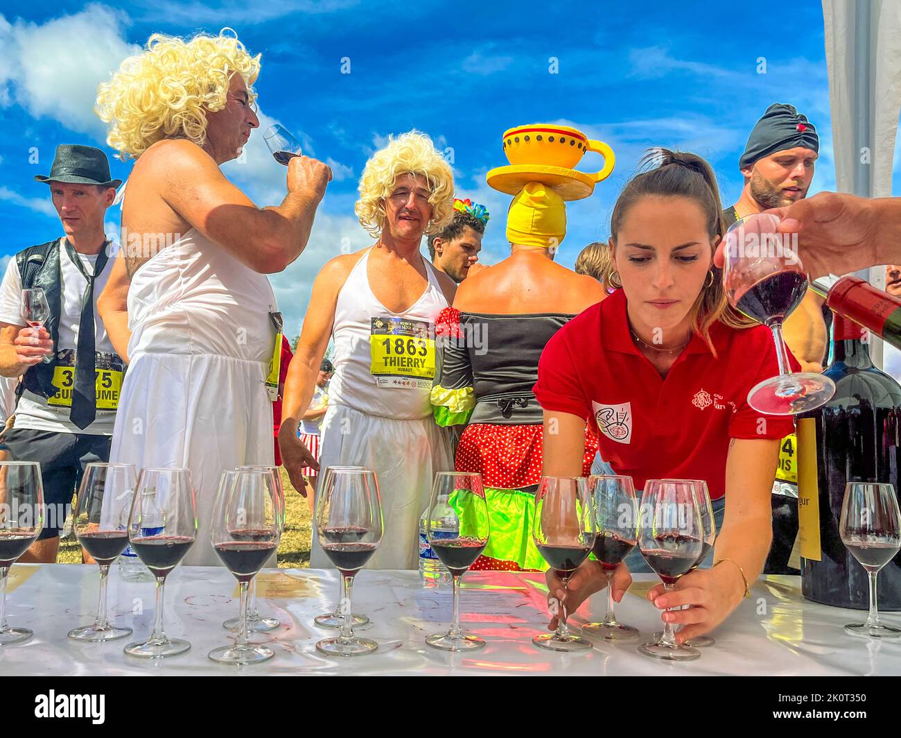 Things are done in style at Chateau Phelan Segur. Here the participants of the 36th Marathon des Chateaux du Medoc are served red wine in glasses Stock Photo