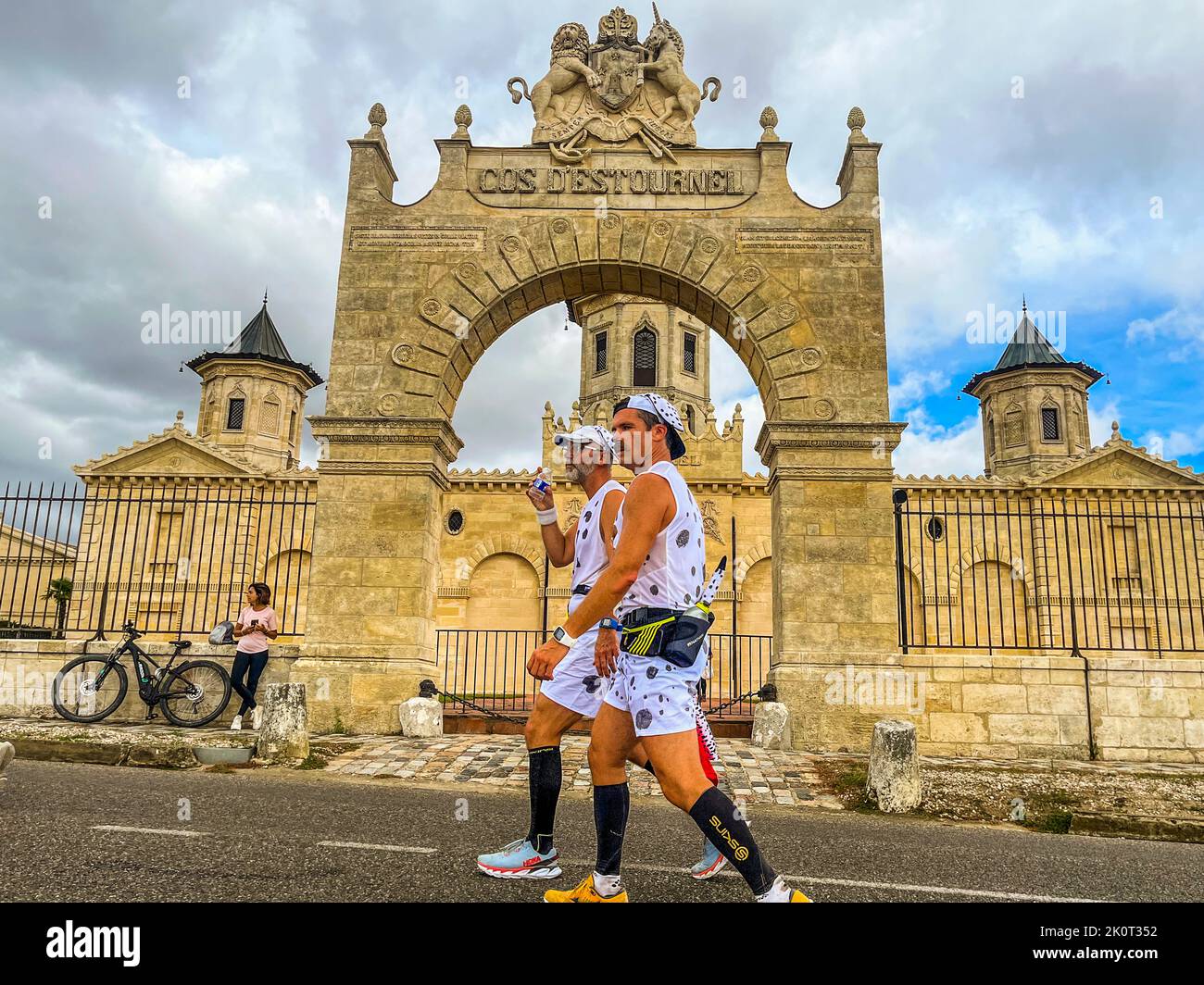 The Château Cos d'Estournel offers an impressive background. Meanwhile, the runners feel the past climbs at the Marathon des Chateaux du Medoc round Lesparre-Médoc, France Stock Photo