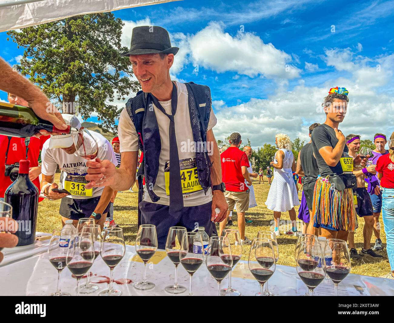 Things are done in style at Chateau Phelan Segur. Here, the participants of the 36th Marathon des Chateaux du Medoc are served red wine in glasses. Many runners can see the glory of the moment Stock Photo