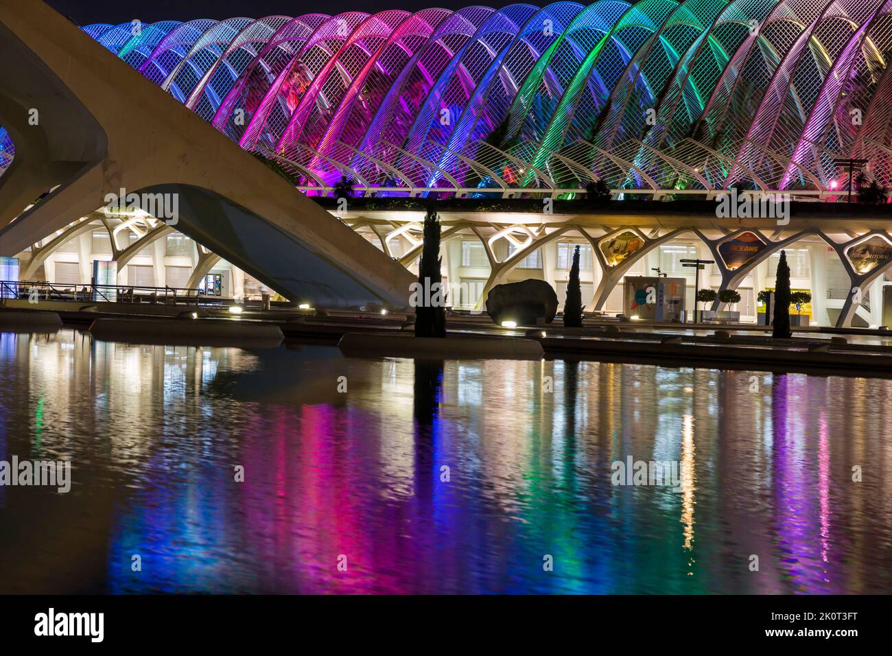 The canopy of the Umbracle gardens illuminated in different colours reflected in water at City of Arts and Sciences in Valencia, Spain in September Stock Photo