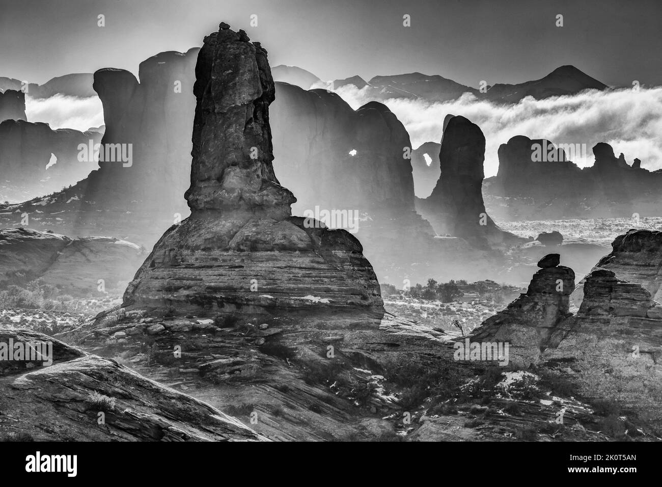 Clearing fog around sandstone rock formations in Arches National Park in winter.  Moab, Utah. Stock Photo
