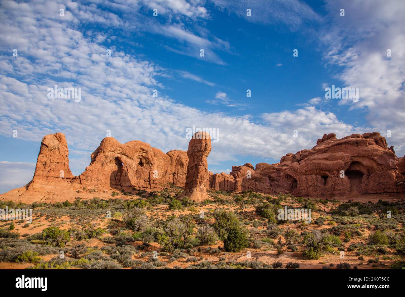 A sandstone rock spire with Double Arch, center, in the Windows Section of Arches National Park, Moab, Utah. Stock Photo