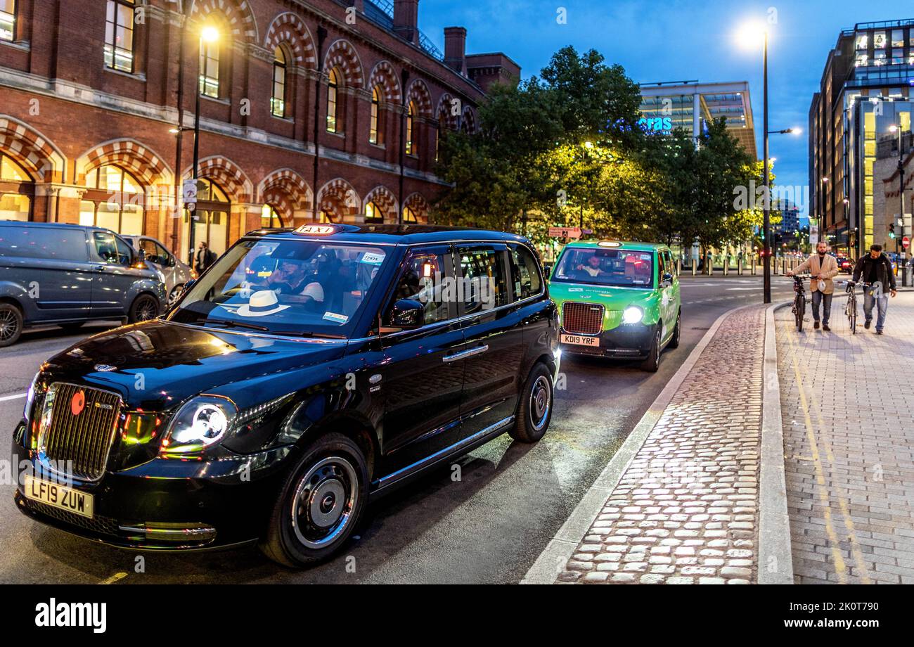London Electric Black Cabs At Kings Cross Station At Night Stock Photo