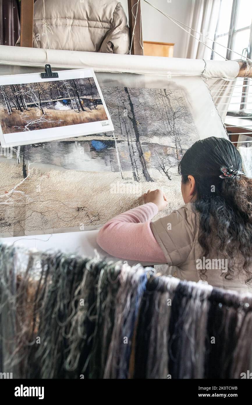 Female factory worker embroidering silk. photo: Bo Arrhed Stock Photo
