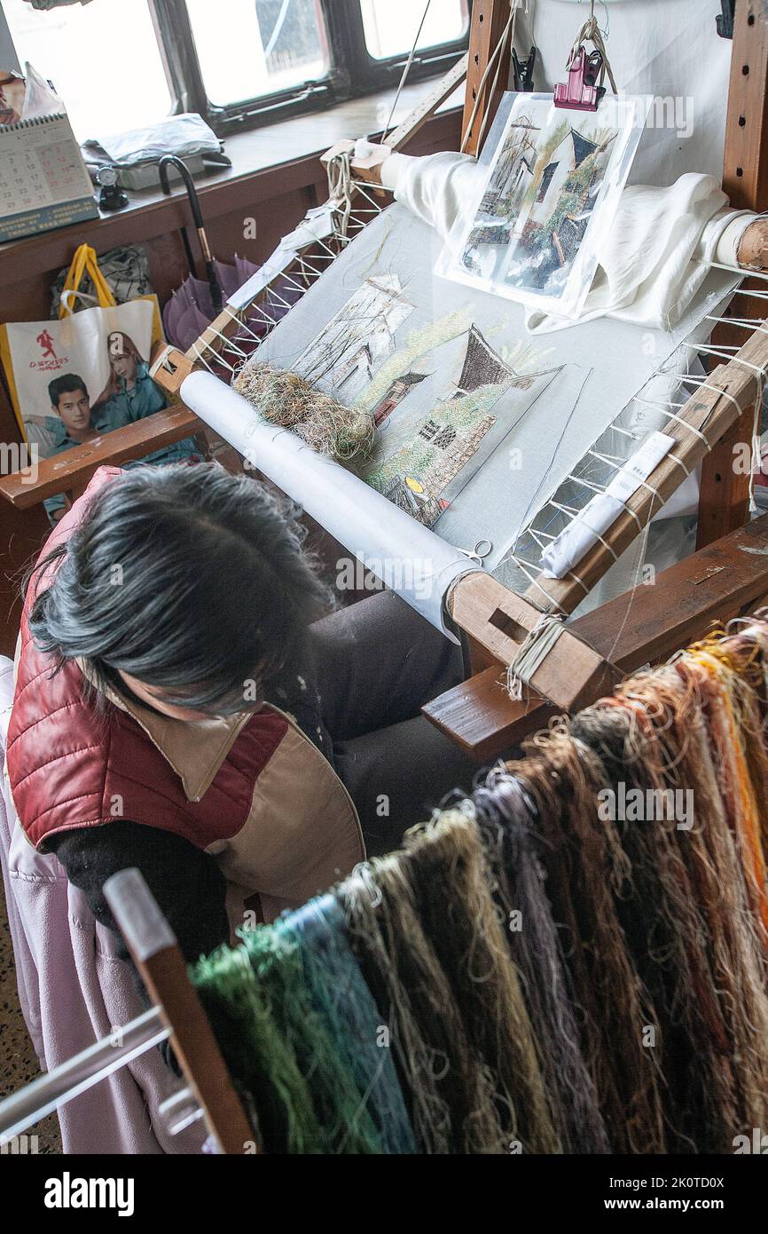 Female factory worker embroidering silk. photo: Bo Arrhed Stock Photo