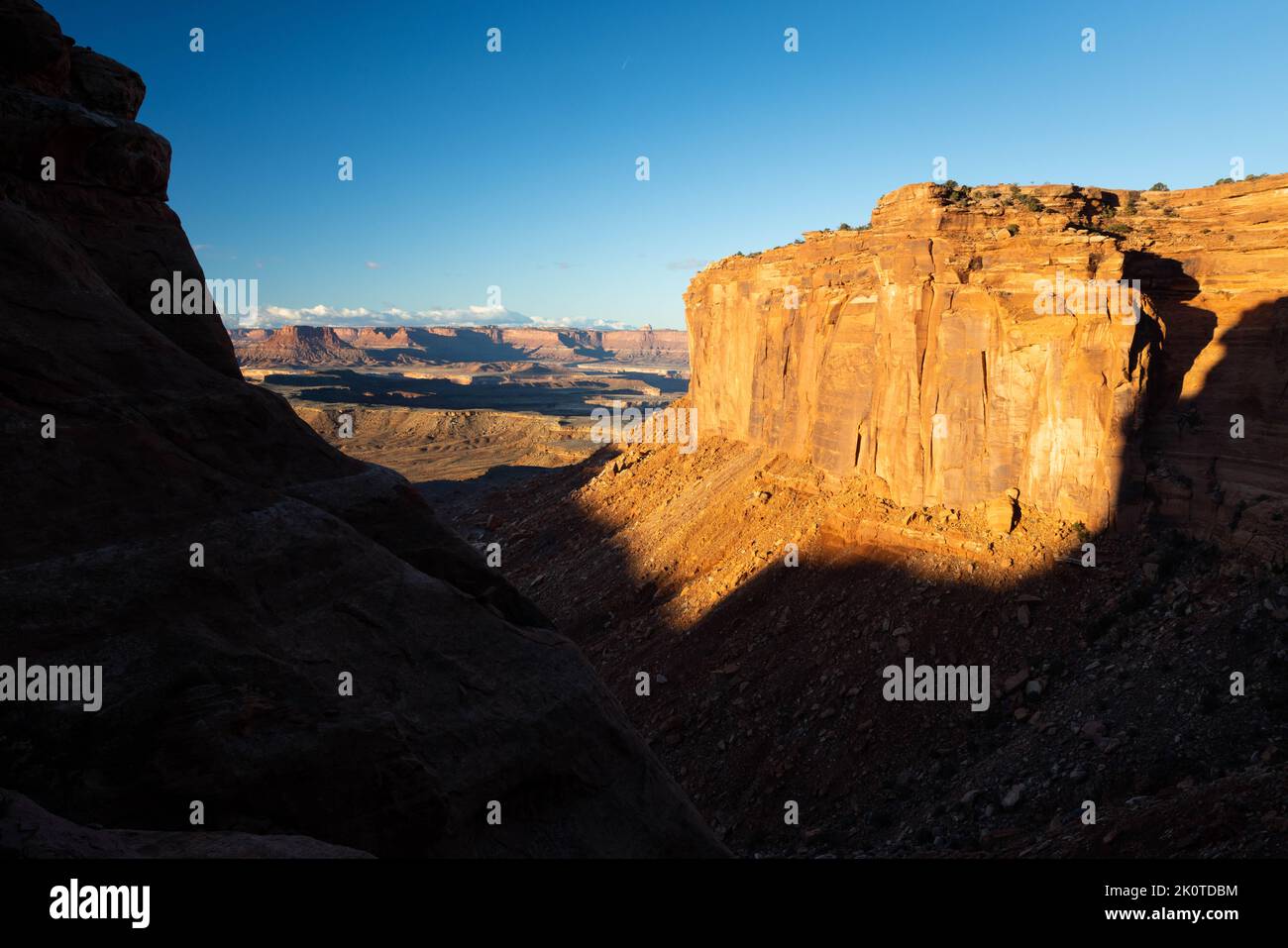 Massive wingate sandstone cliffs creating a deep and steep canyon along the Murphy Trail as it descends from the Island in the Sky. Canyonlands Nation Stock Photo