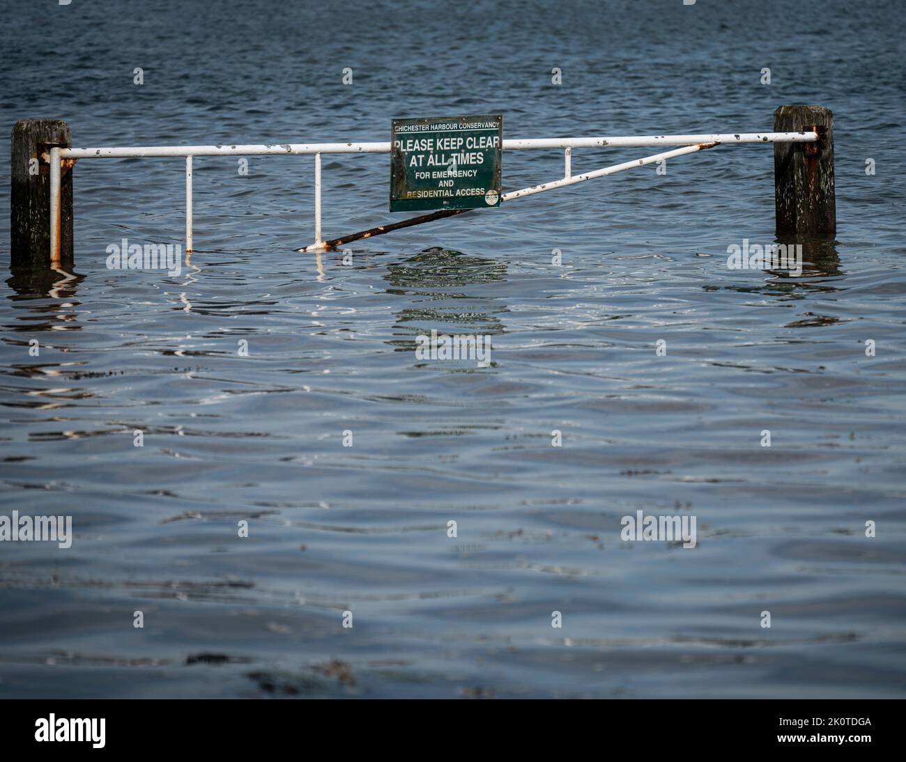 Partially submerged flood barrier across the entrance to Langstone harbour, Hayling Island, UK. Stock Photo