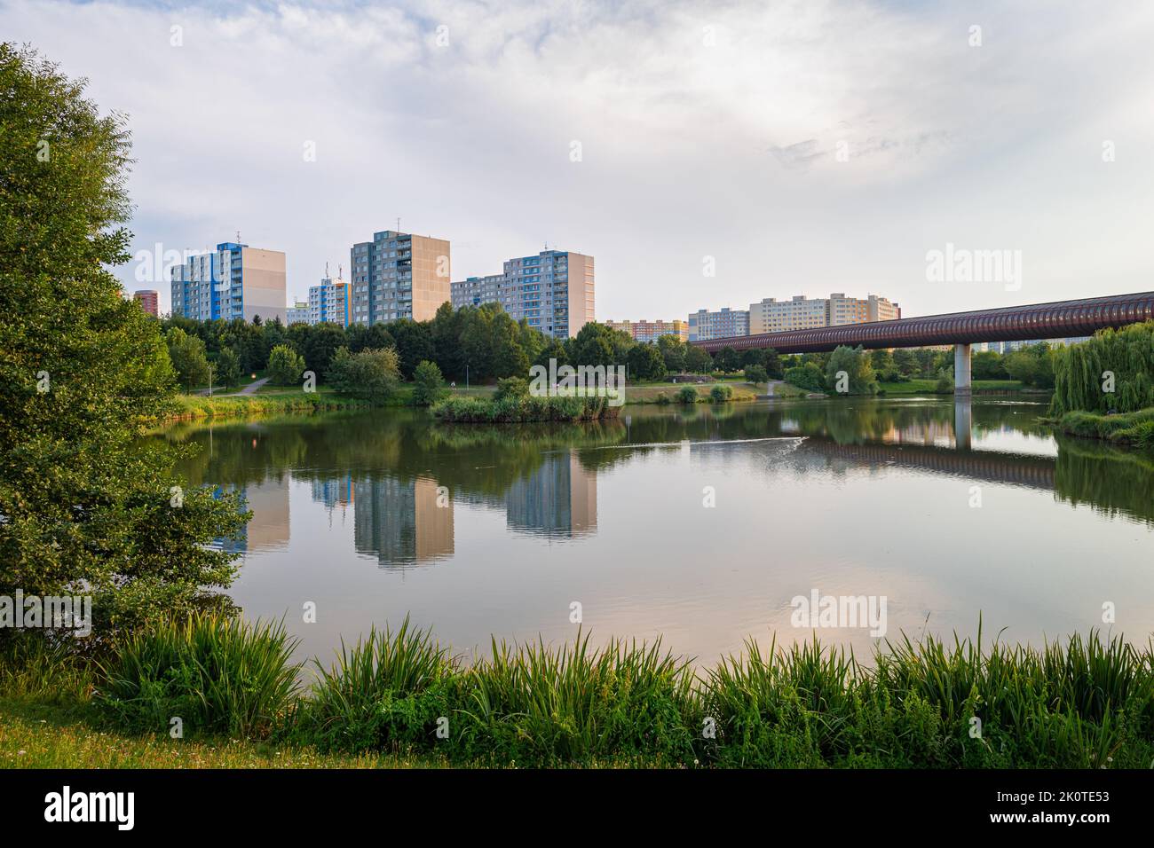 Small lake in a city park and high-rise apartment buildings in suburban area Lužiny in the city of Prague Stock Photo