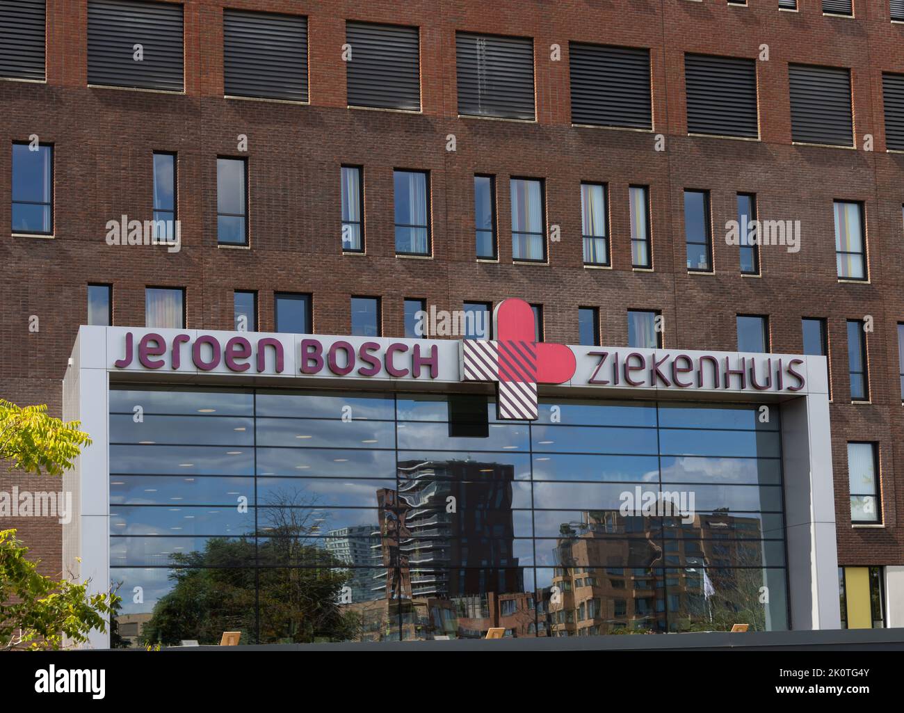 Close-up of the main entrance of 'Jeroen Bosch'-hospital. Reflection in the glass shows residential buildings. Stock Photo