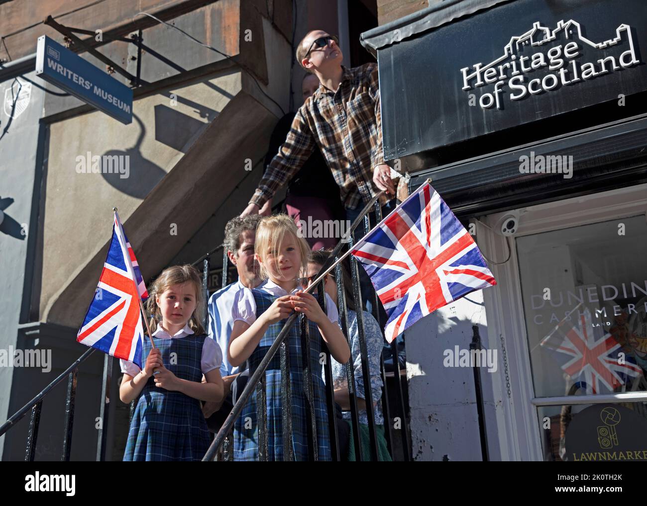 Royal Mile, Edinburgh, Scotland, UK. Crowds gather for Coffin of Her Majesty Queen Elizabeth II departing St Giles Cathedral.13th September 2022. Pictured: This family from Stirling wait on steps for the coffin to pass. Credit: Arch White/alamy live news. Stock Photo