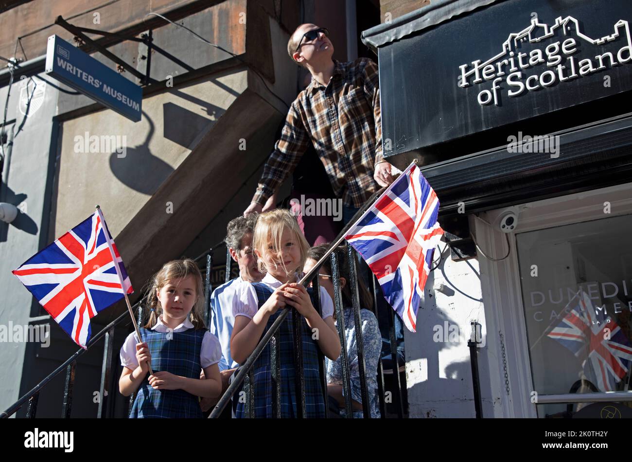 Royal Mile, Edinburgh, Scotland, UK. Crowds gather for Coffin of Her Majesty Queen Elizabeth II departing St Giles Cathedral.13th September 2022. Pictured: This family from Stirling wait on steps for the coffin to pass. Credit: Arch White/alamy live news. Stock Photo