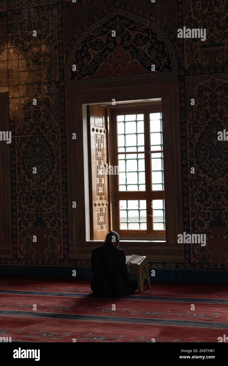 Islamic vertical photo. Elder muslim man reading the Holy Quran in the mosque. Ramadan or kandil or laylat al-qadr or kadir gecesi background. Ankara Stock Photo