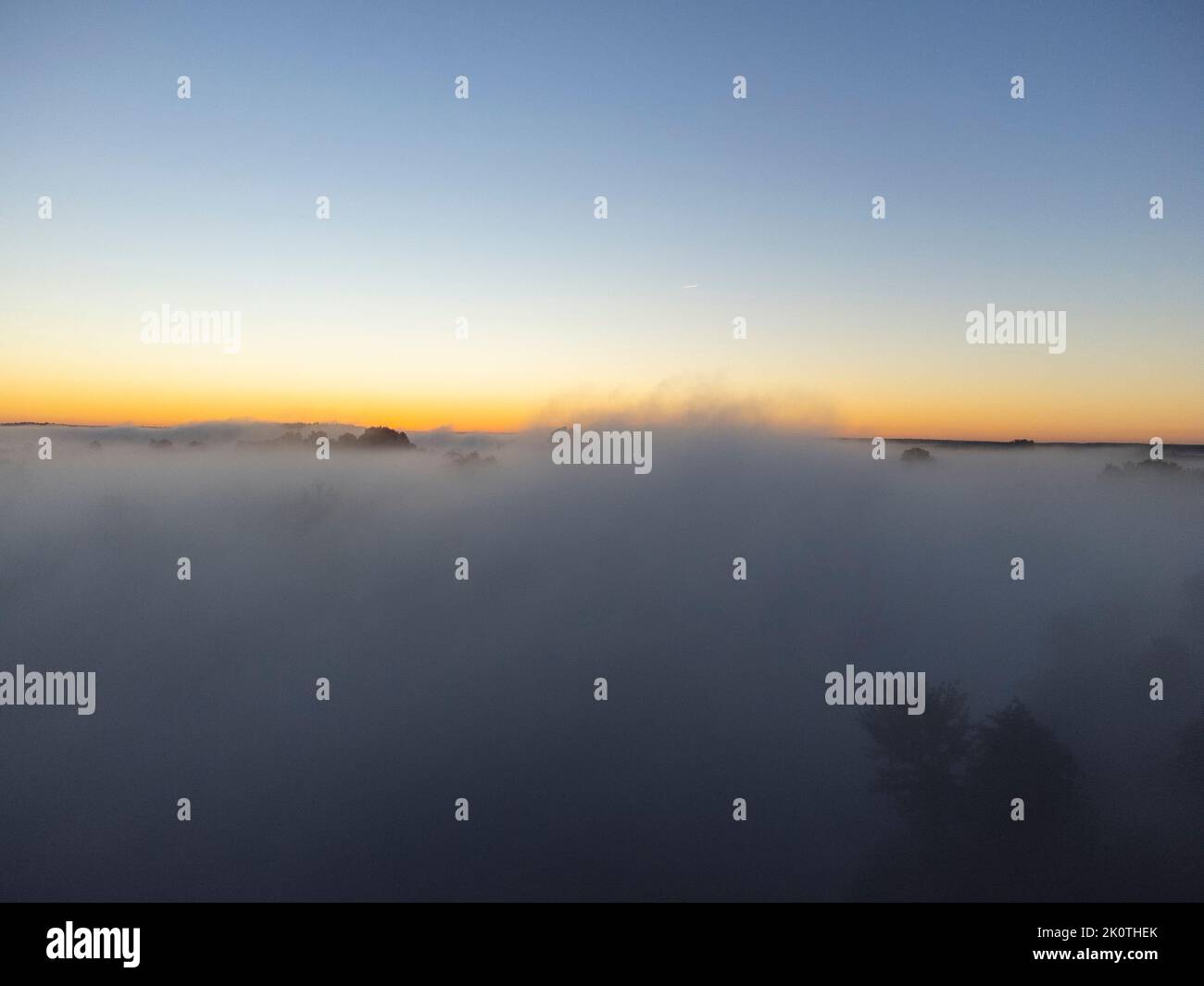 Pictures of the drone flight over the fog. River, forest, fields and meadows on a misty summer dawn. Stock Photo