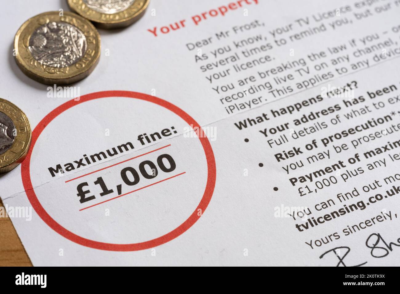 TV licensing Under Investigation letter for late / non payment of the BBC TV license fee warning of a maximum fine of £1000, with pound coins Stock Photo