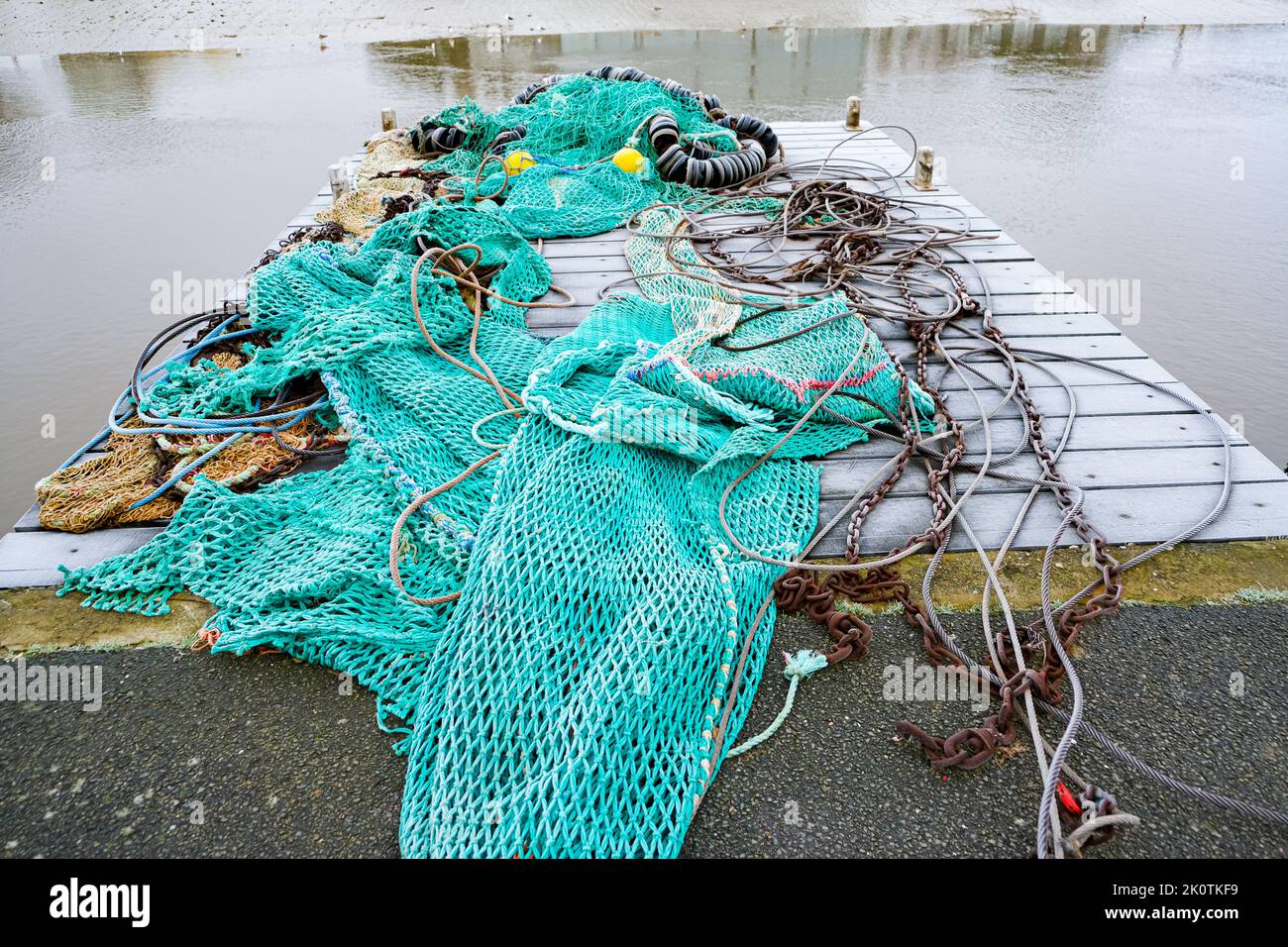 blue fishing net on a pontoon with its ropes and floats covered with ...