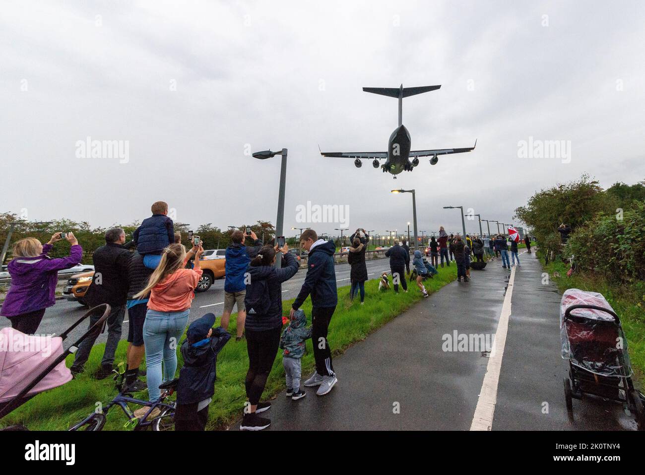 RAF Northolt, South Ruislip, London, UK. 13th Sep, 2022. The body of Queen Elizabeth II has been flown from Edinburgh Airport by Royal Air Force Boeing C-17A Globemaster III serial number ZZ177 and is seen on finals to land at RAF Northolt. The coffin will then be transferred to road transport for the journey to Buckingham Palace. The large transport aircraft landed over the A40 and members of the public that had braved the rain. Callsign Kittyhawk for the Queen for the final time Stock Photo