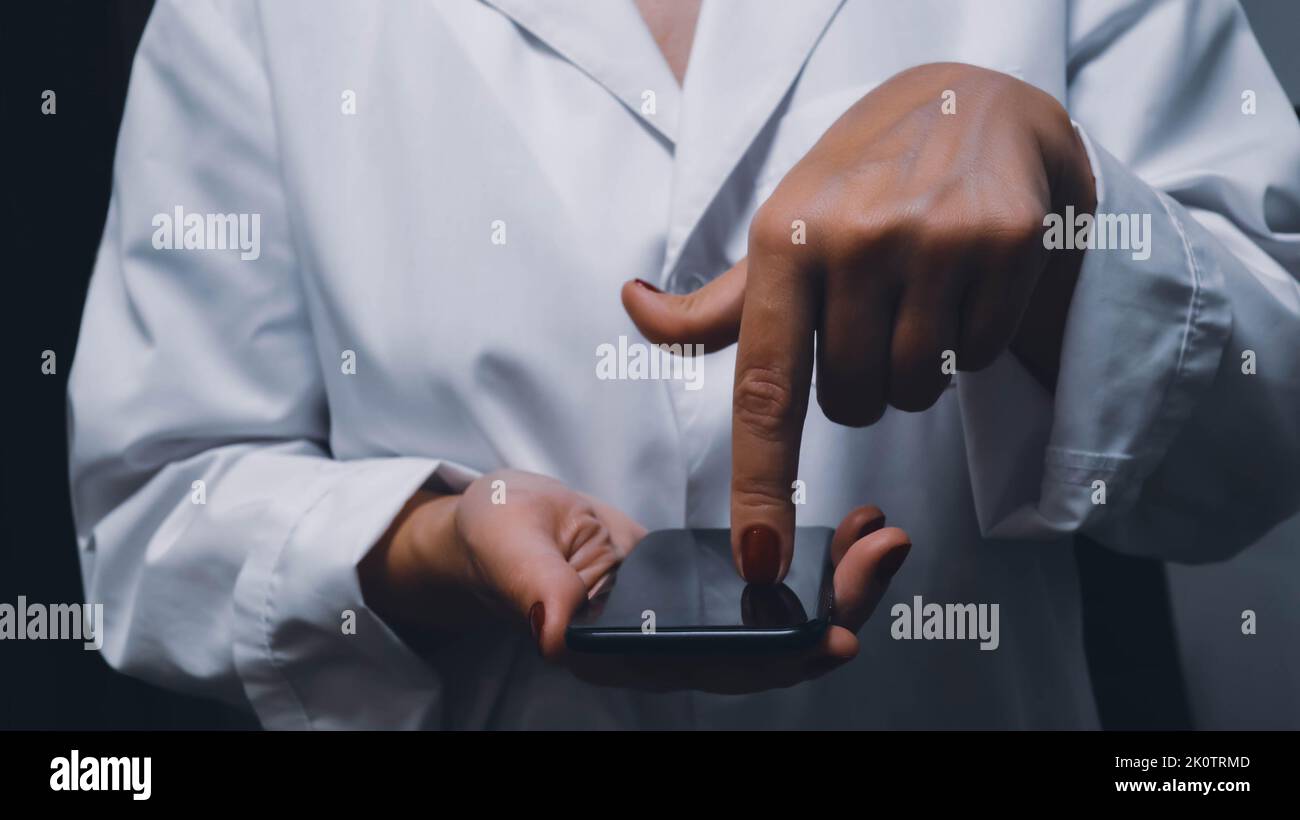 Phone doctor consultation closeup concept image. Front view photo of female physician pressing on smartphone screen. Picture for web banner, landing p Stock Photo