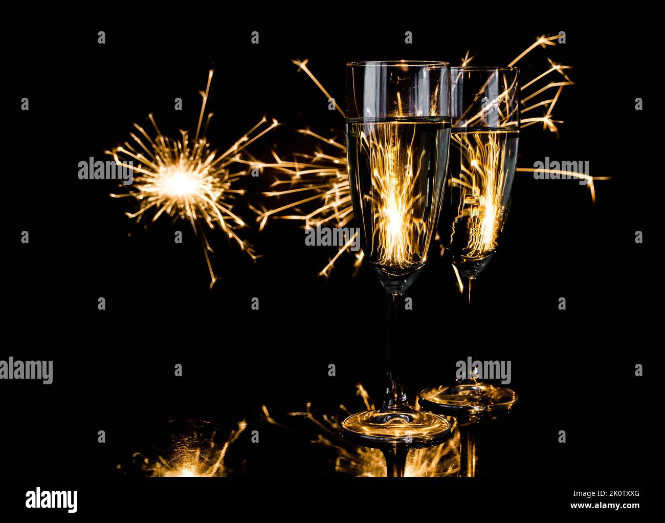Two glasses of champagne with sparklers in background. New Year's Eve ...