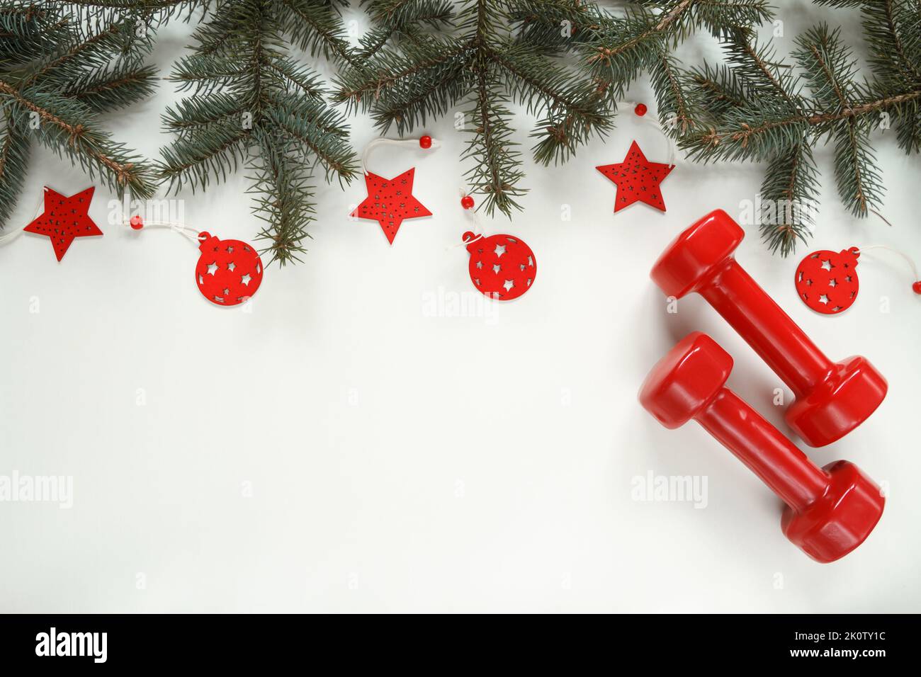 Red gym dumbbells, Christmas tree branches, decorations and pendant